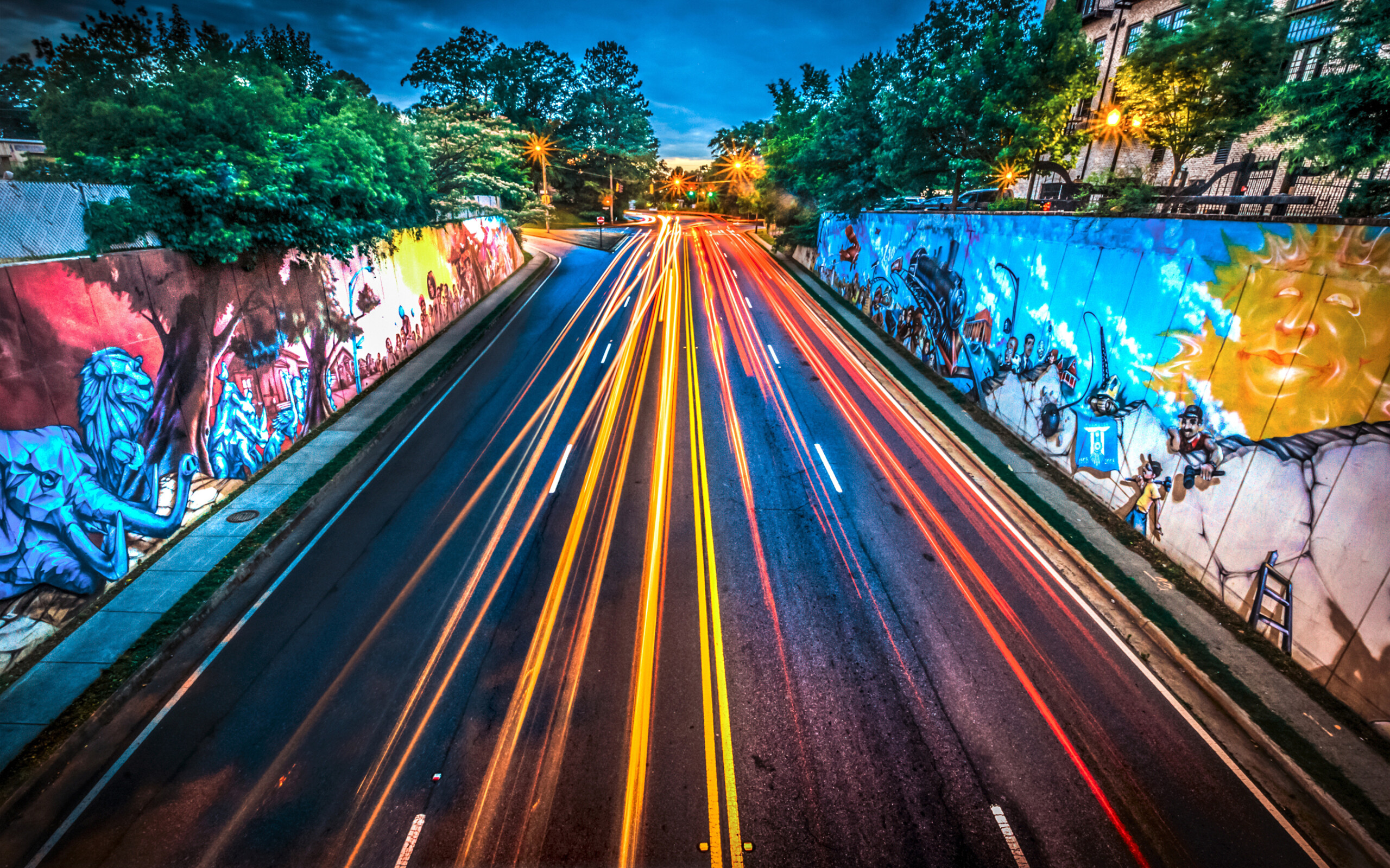 Traffic travels past colorful murals along Chamblee-Dunwoody Road, June 1, 2014, in Chamblee, Georgia. The 100-by-20 foot murals were painted in 2008 by local graffiti artist Amir Totem for Chamblee's centennial celebration. (Photo by Carmen K. Sisson/Cloudybright)