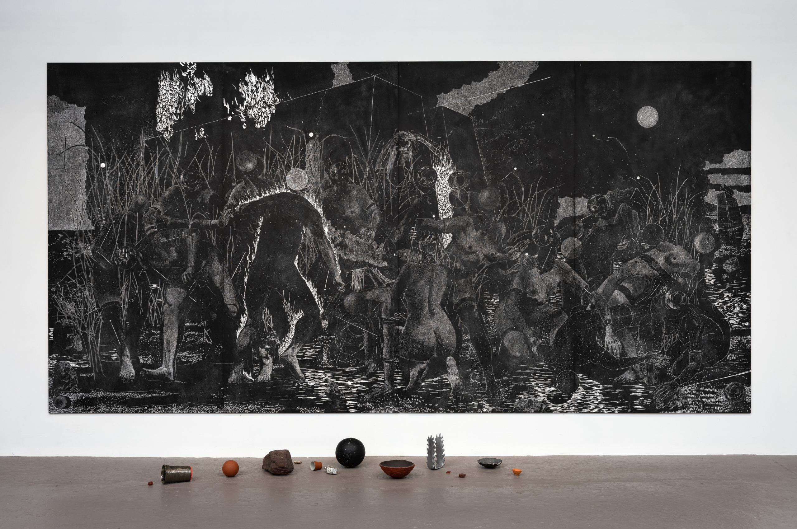 Large black and white gallery mural with floor sculptures