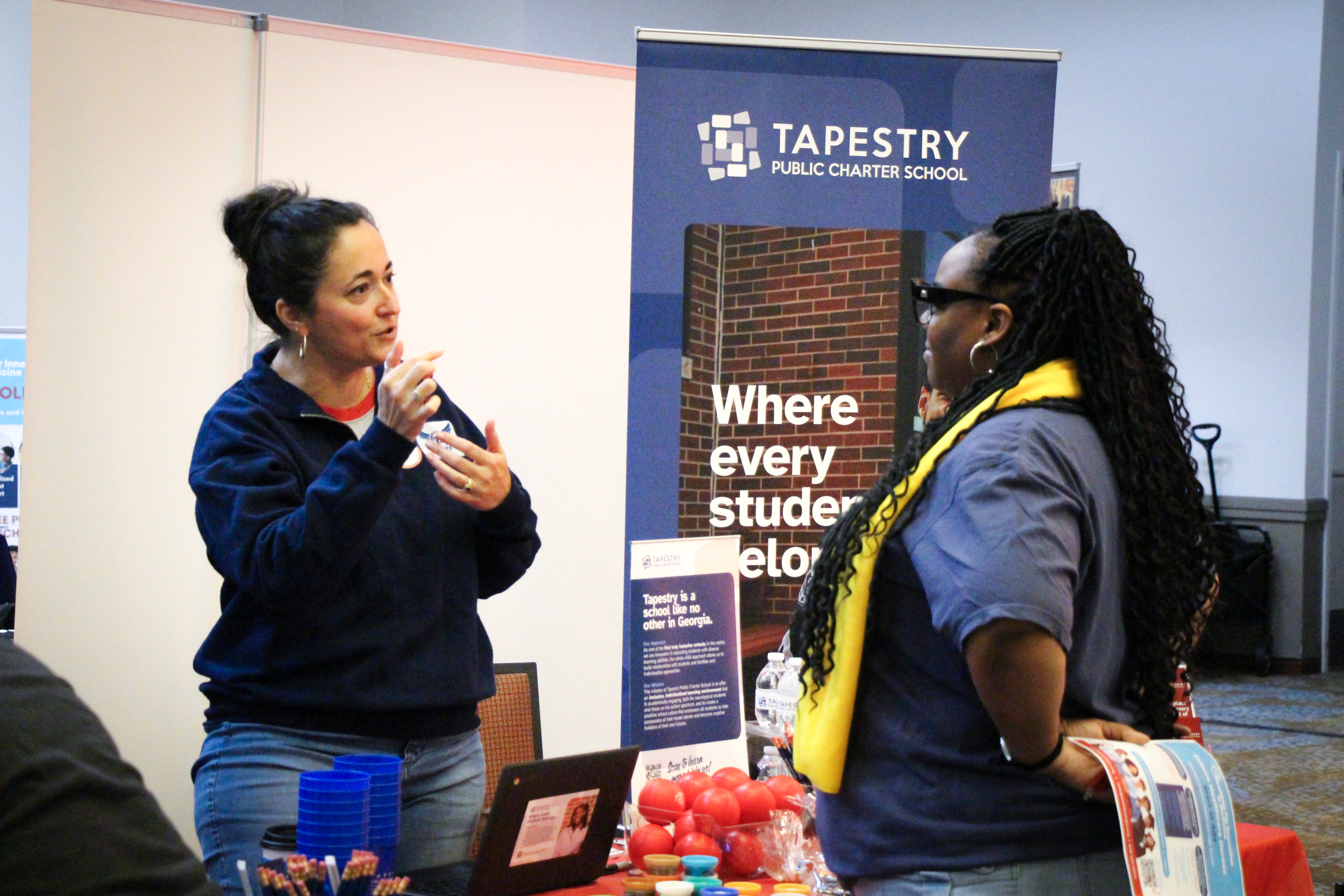 Woman speaking at Tapestry Public Charter School information booth