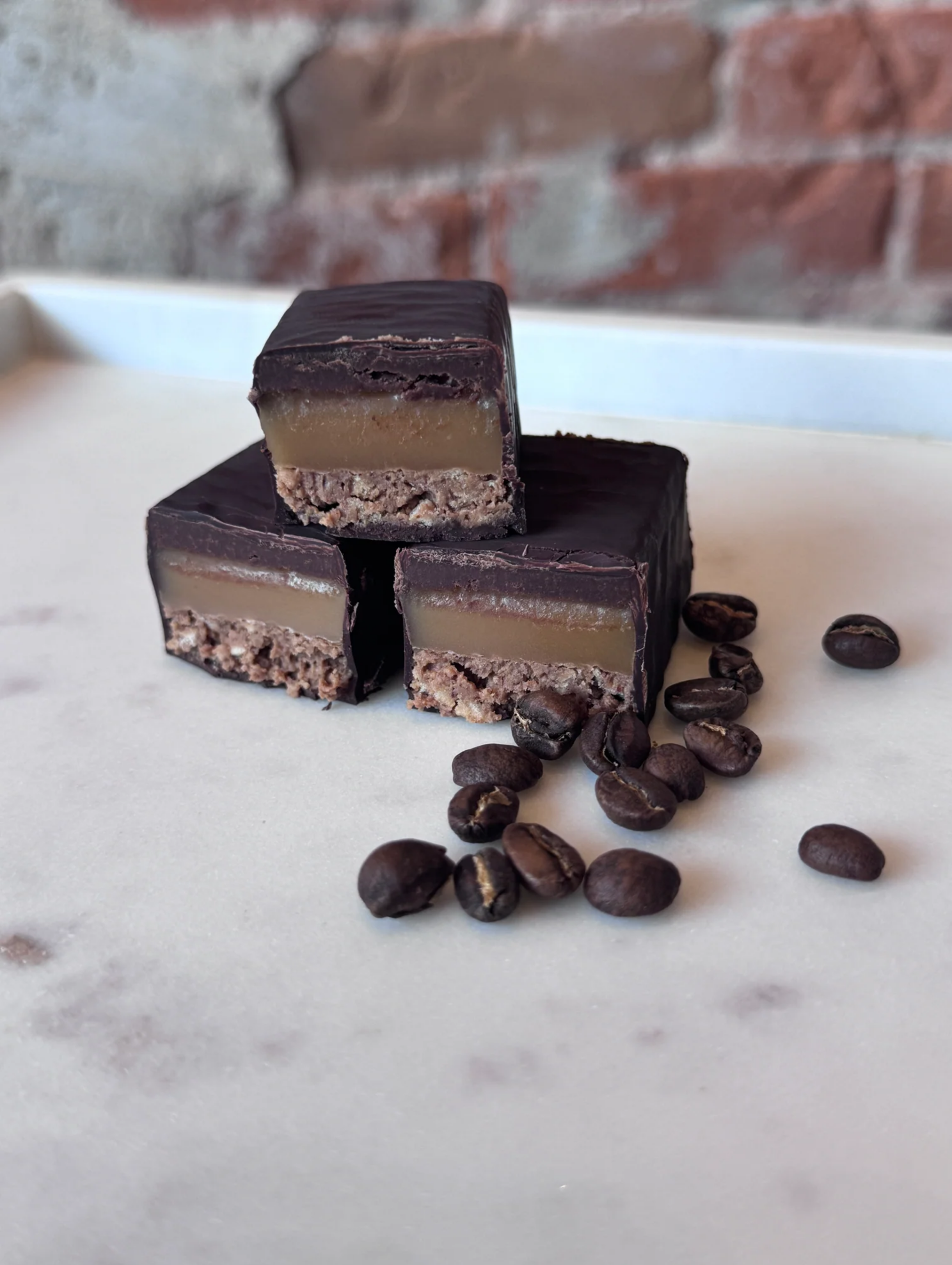 Chocolate caramel bars stacked with coffee beans
