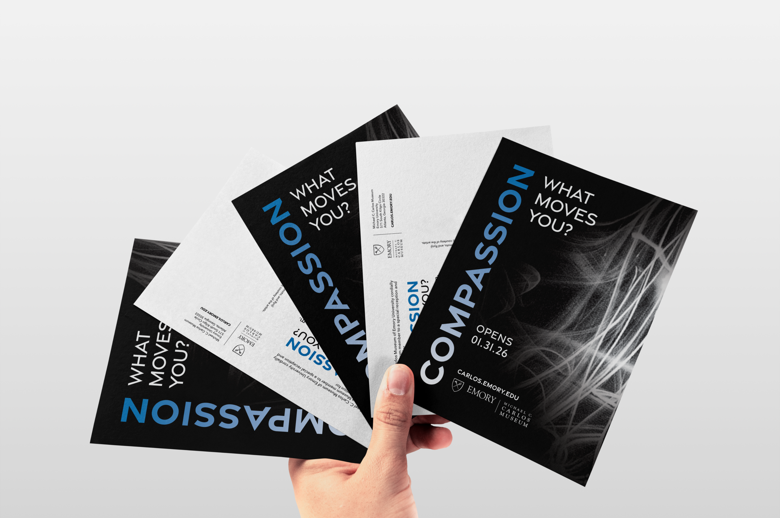 Hand holding Carlos Museum Compassion exhibit invitation cards