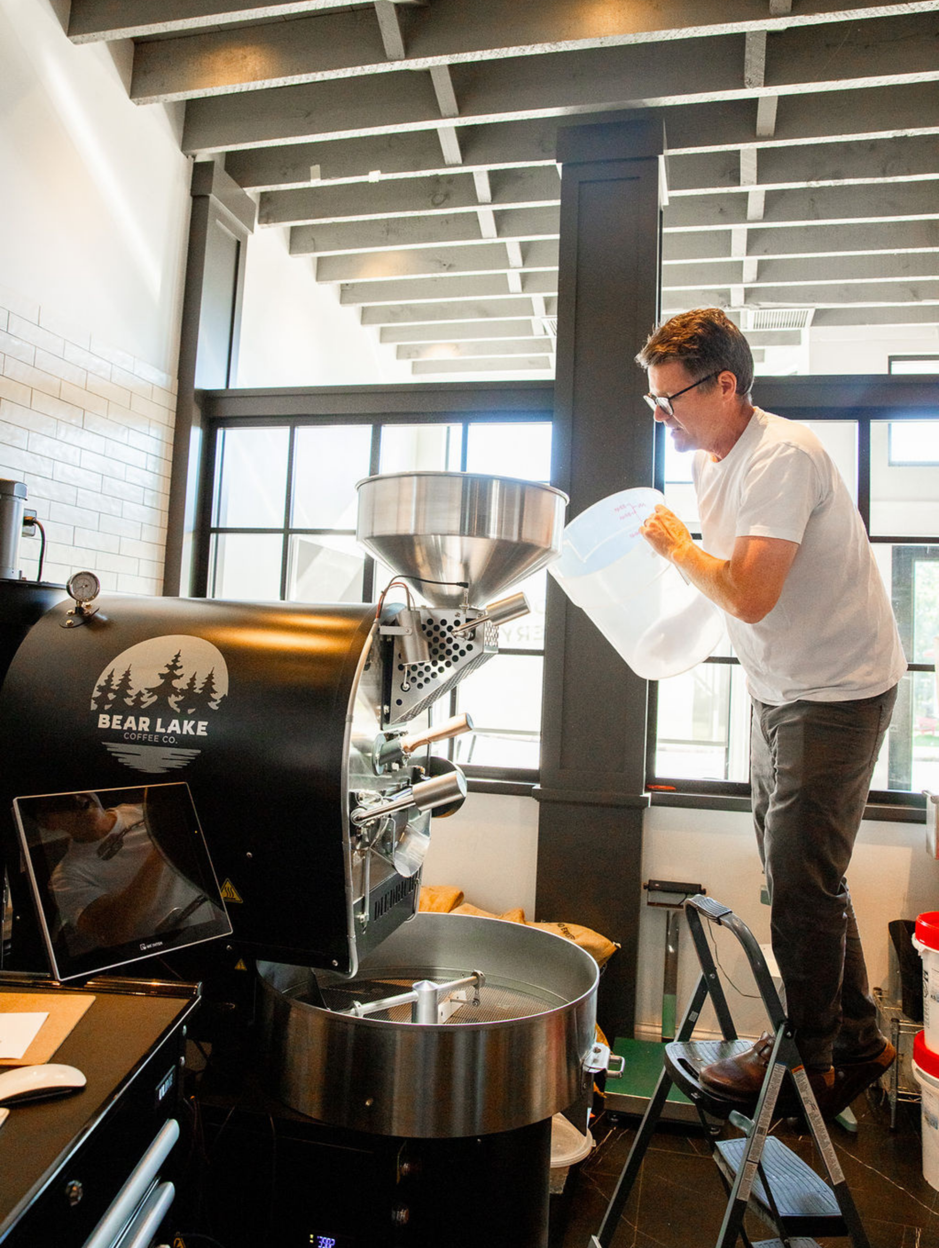 Man pours coffee beans into Bear Lake roaster machine