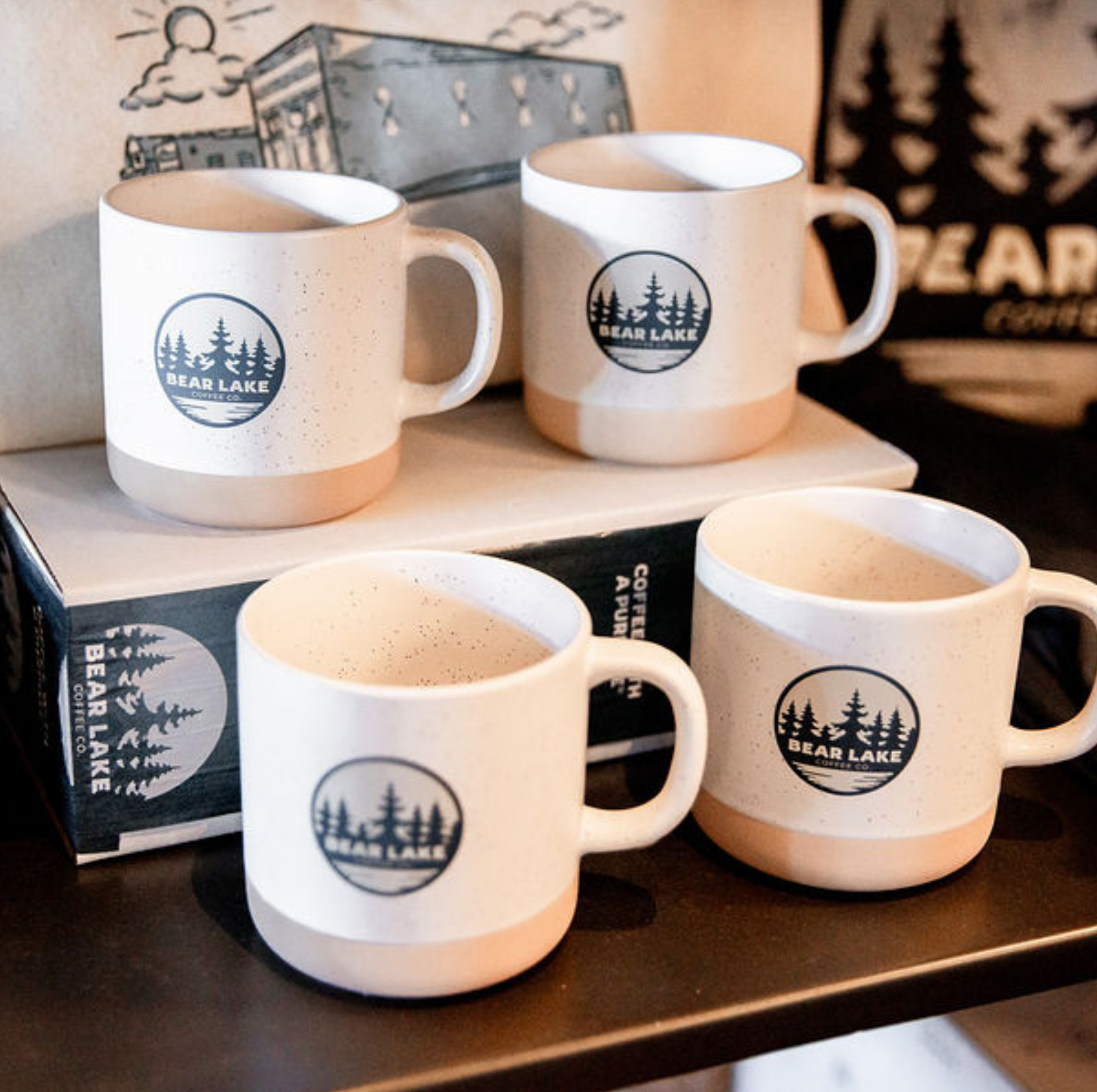 Four Bear Lake Coffee Co. branded ceramic mugs on display